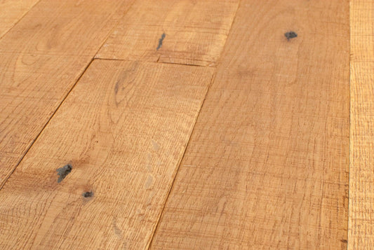 Close-up view of wooden floorboards with a natural grain pattern and visible knots.