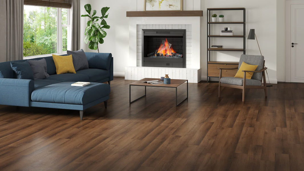 hardwood flooring in the living room space with couch and fireplace