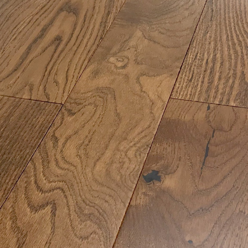 Close-up of brown wooden floorboards with visible grain patterns and a few dark knots.